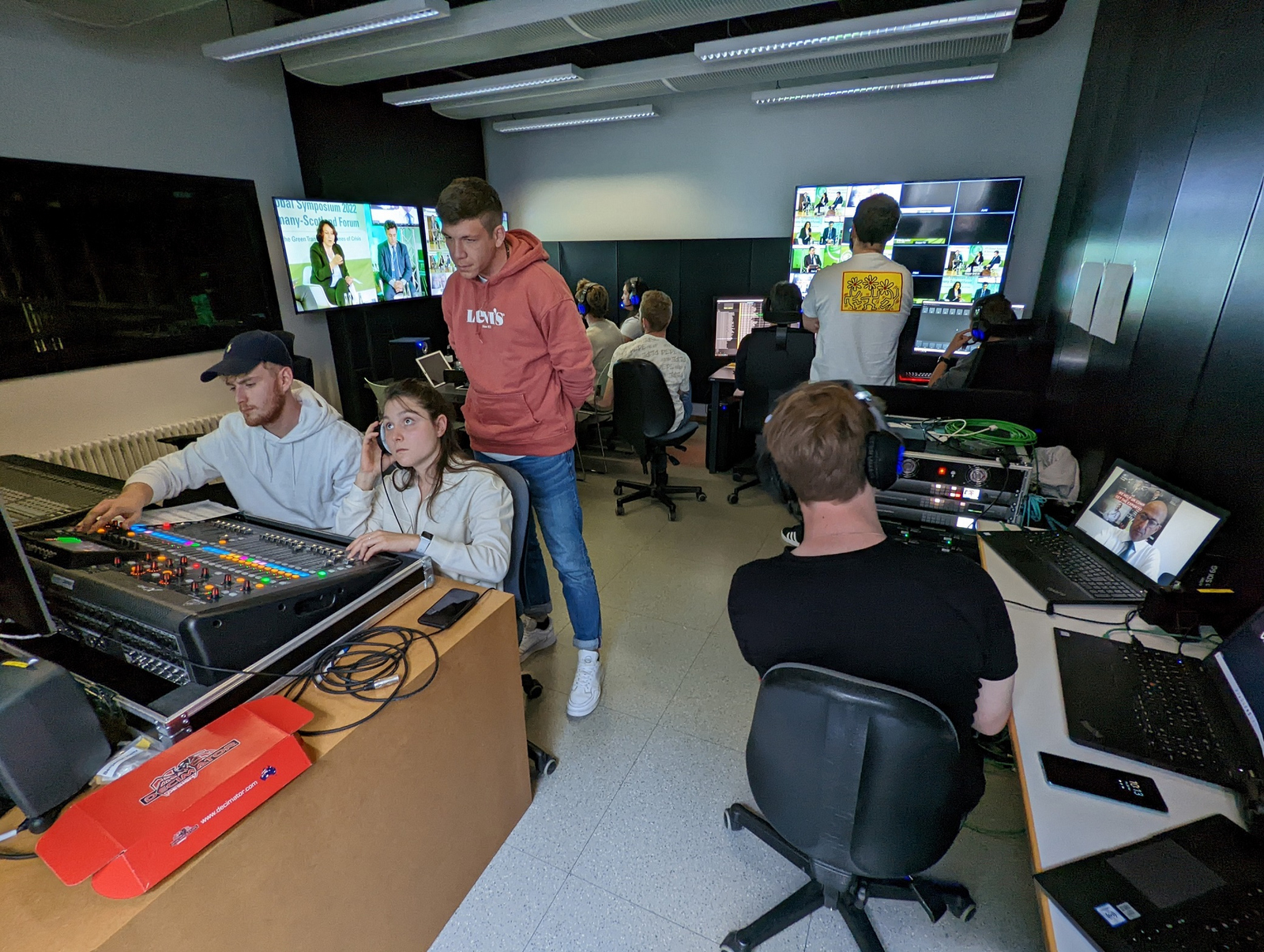 Blick in Offenburger Studio in dem ganz viele Studierenden vor diversen Bildschirmen und Reglern sitzen oder stehen
