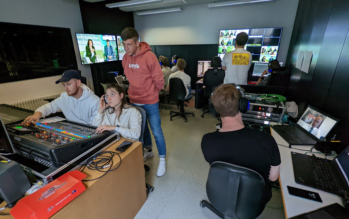 Blick in Offenburger Studio in dem ganz viele Studierenden vor diversen Bildschirmen und Reglern sitzen oder stehen