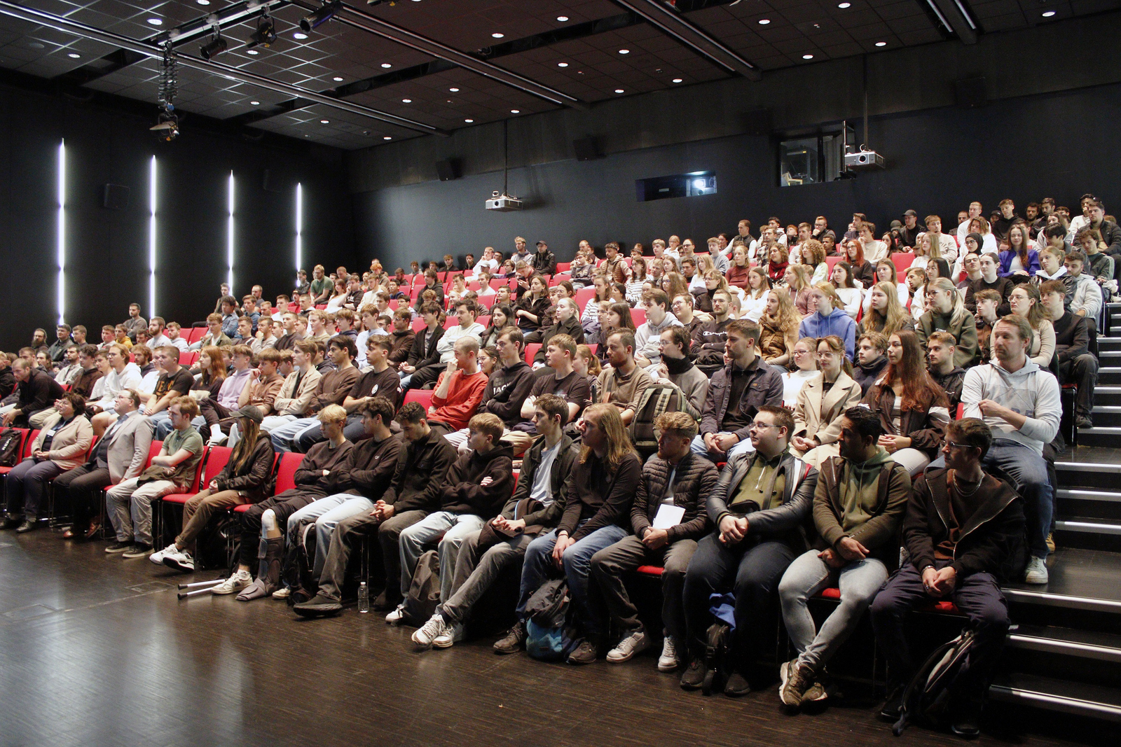 Junge Leute sitzen dicht gedrängt in einem Hörsaal