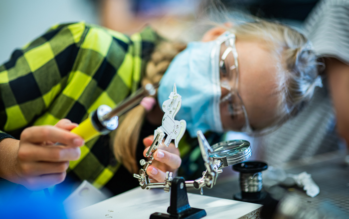 Ein Mädchen lötet ein Einhorn.