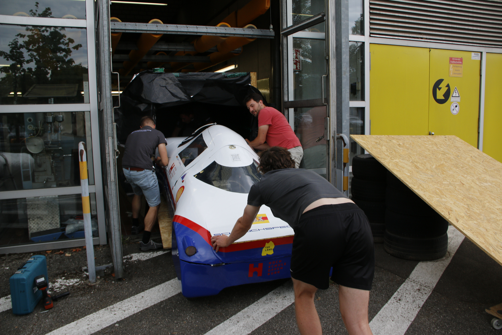 Studierende schieben Auto in Kiste