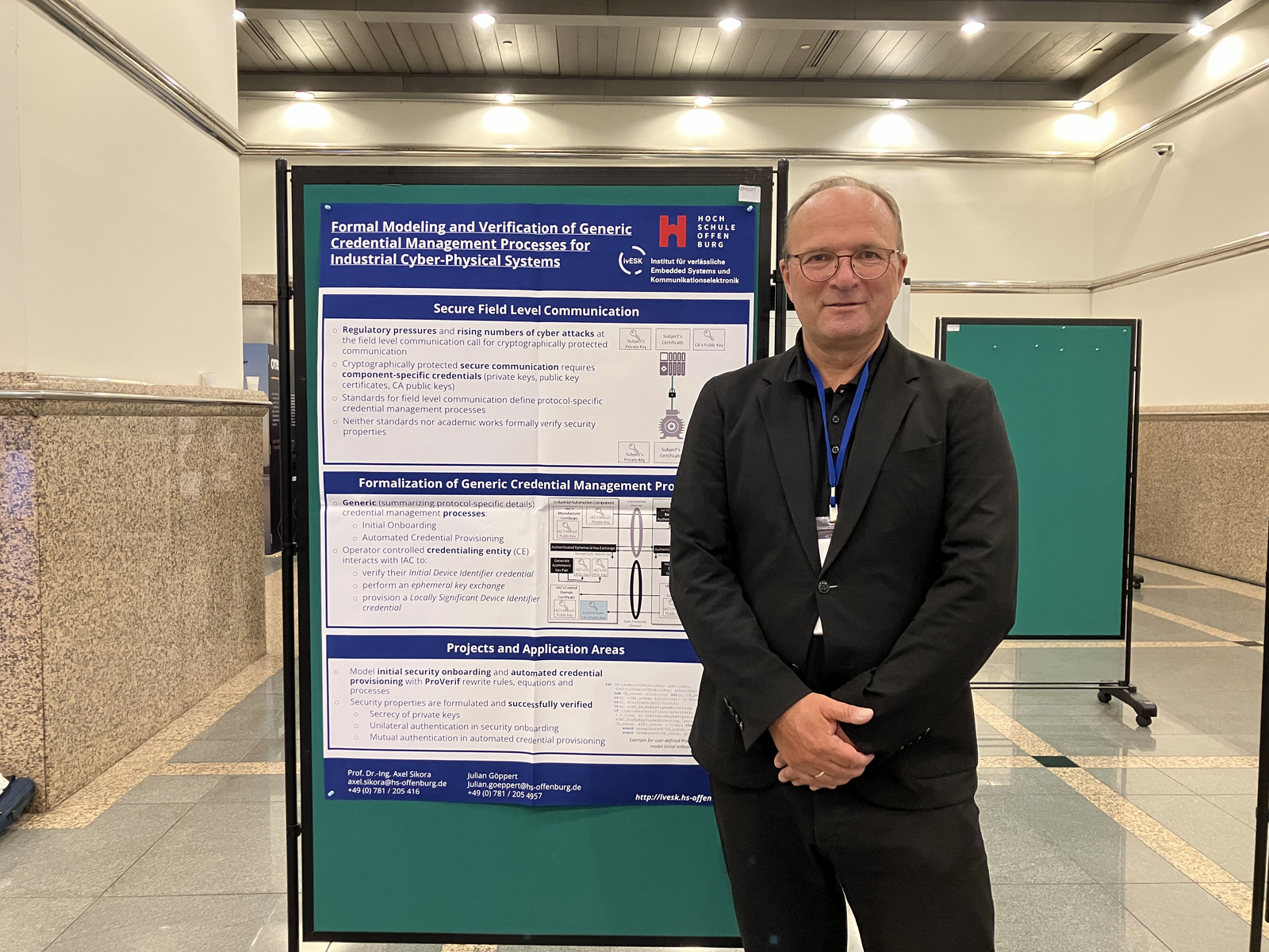 Prof. Dr. Axel Sikora vor einem der beiden Poster 