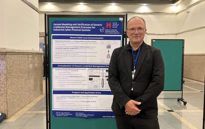 Prof. Dr. Axel Sikora vor einem der beiden Poster 
