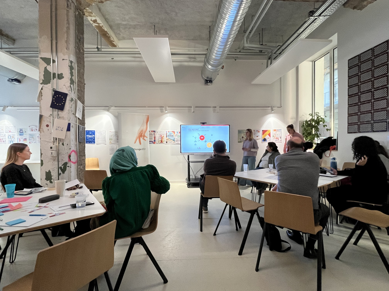 Personen stehen vor der Gruppe und stellen ihre Projekte während der Veranstaltung vor