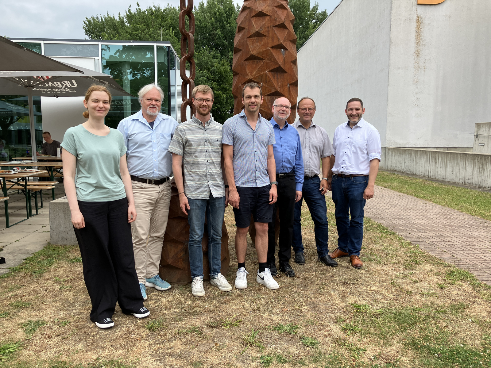 1 Frau und 6 Männer stehen in Reihe