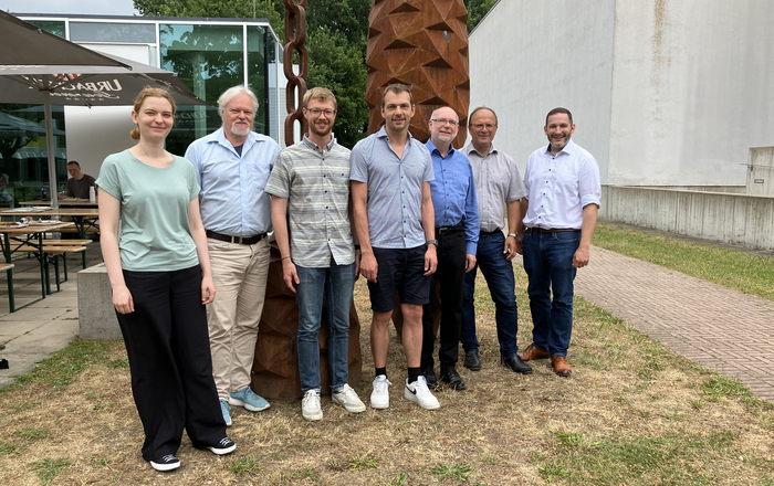 1 Frau und 6 Männer stehen in Reihe