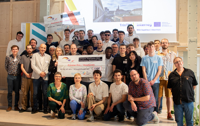 Gruppenfoto aller Teilnehmenden, Betreuenden und Jurymitglieder mit Siegerschecks