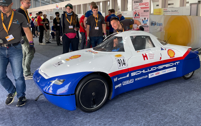 Teammitglieder schieben Schluckspecht aus der Boxengasse
