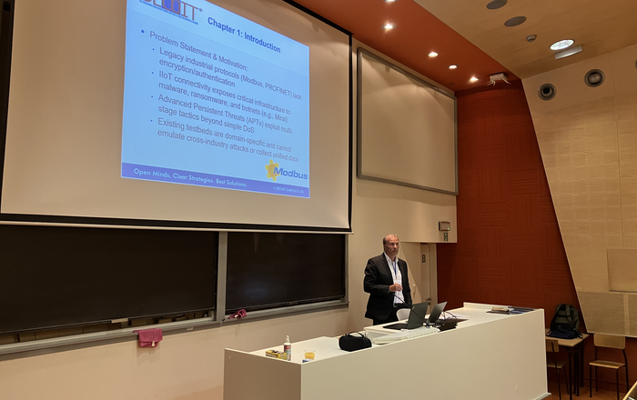 1 Redner am einem Pult vor einer Leinwandpäsentation