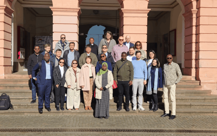 Gruppenfoto auf einer Treppe von dem internationalen Besuch vor einem Gebäude