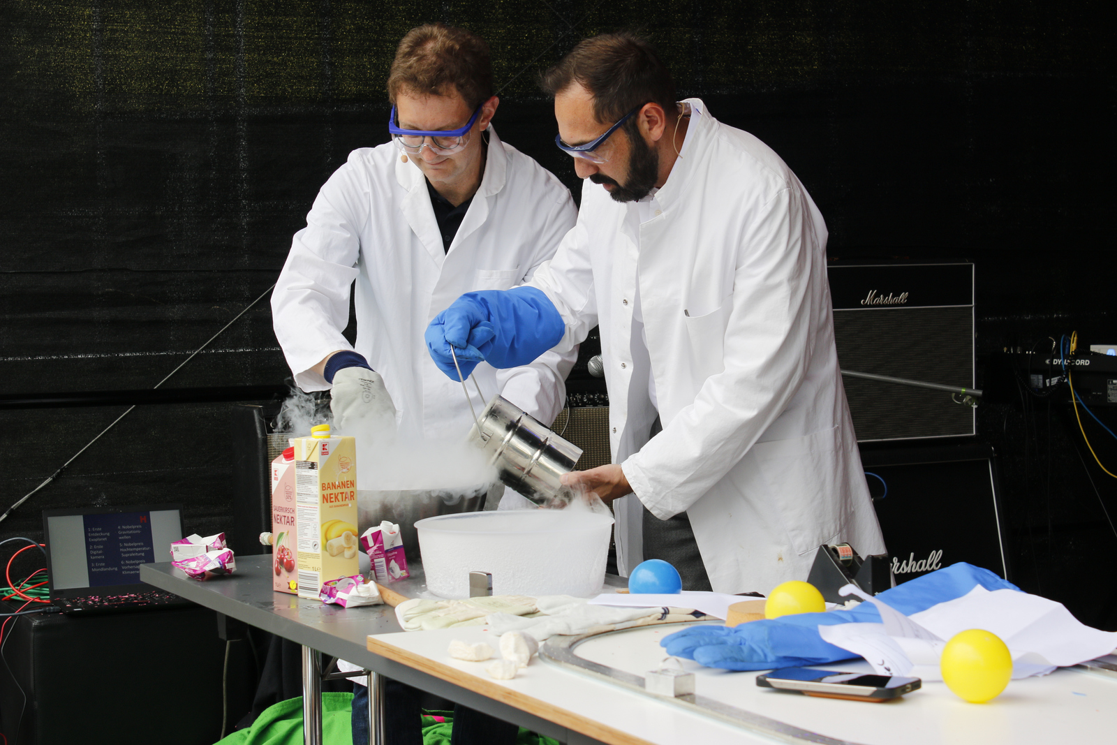 Zwei Männer rühren in eine Schüssel aus der Nebel aufsteigt.