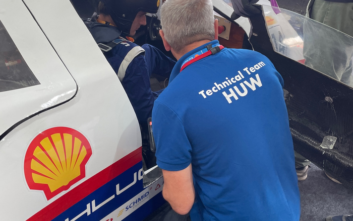 Huw vom Technical Team kniet neben der Fahrzeugtur 