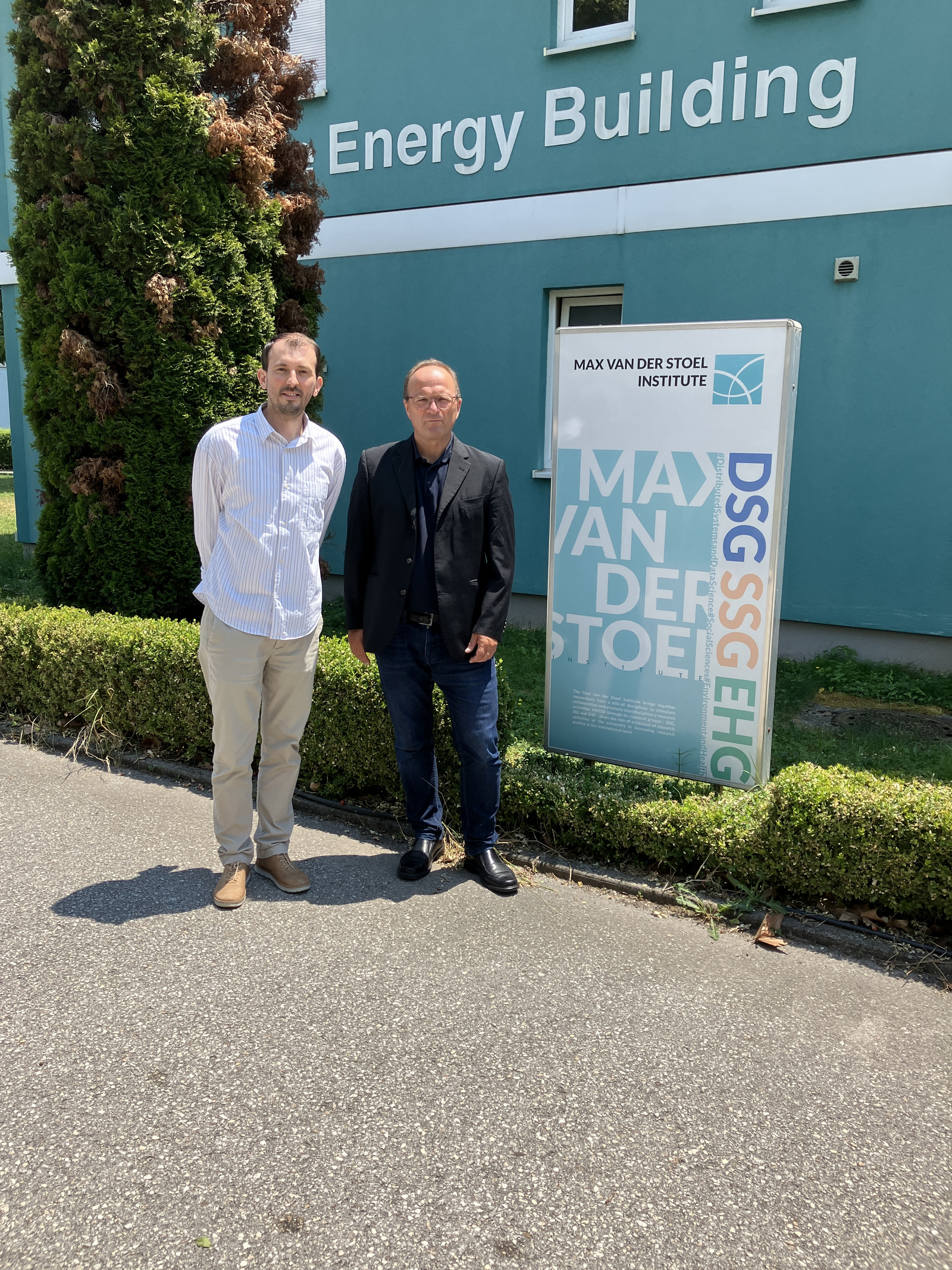 2 Peronen  neben einem Institutsschild stehend