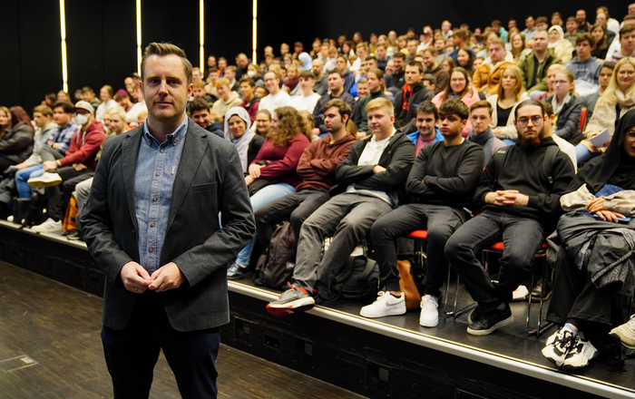 Prorektor Prof. Dr. Oliver Schäfer steht im Winfried-Lieber-Saal vor den mit Erstsemestern vollbesetzten ansteigenden Stuhlreihen