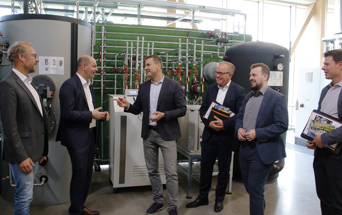 Die Herren stehen vor einer Heizungsanlage im RIZ Energie