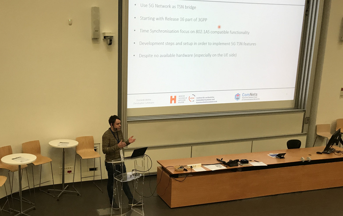 a Speaker in front of a presentation board