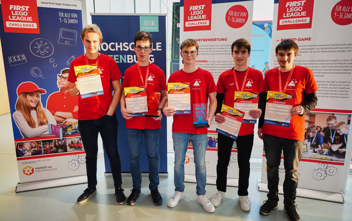Die fünf Jungen in ihren roten Team-T-Shirts präsentieren ihre Urkunden und den Pokal
