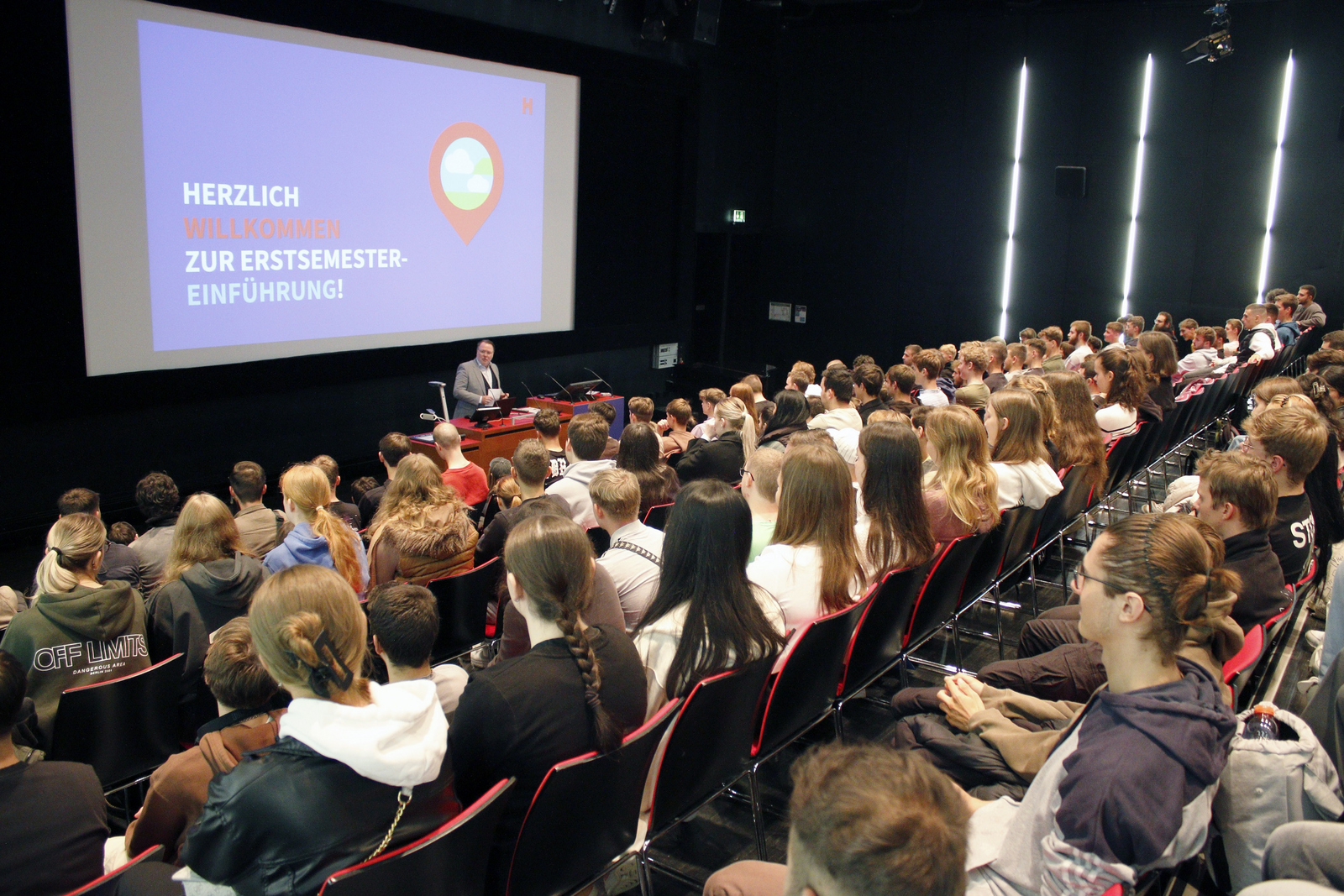 Ein Mann spricht in einem vollbesetzten Hörsaal zu jungen Leuten