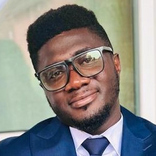 Porträt von Stephen Osei Kuffour im blauen Anzug mit Krawatte und Brille