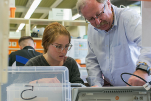 Professor unterweist Studentin im Physiklabor