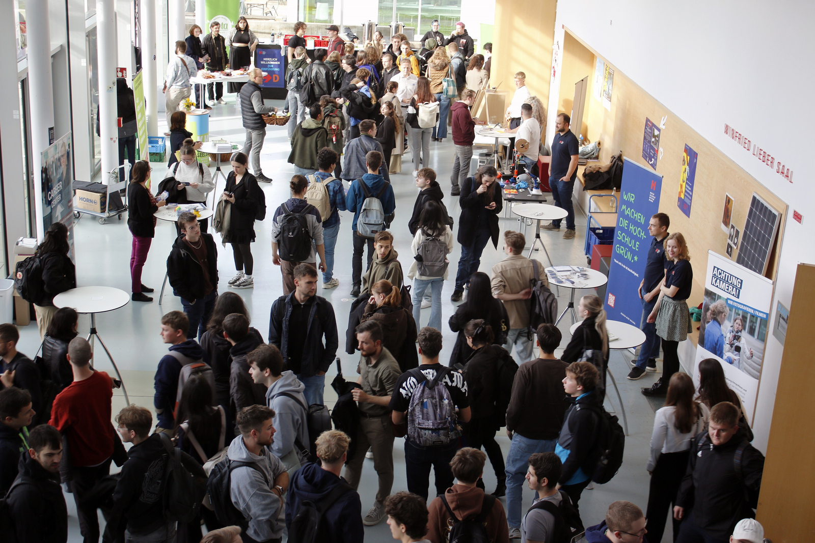 Blick von oben auf zahlreiche junge Leute im Foyer von Gebäude D