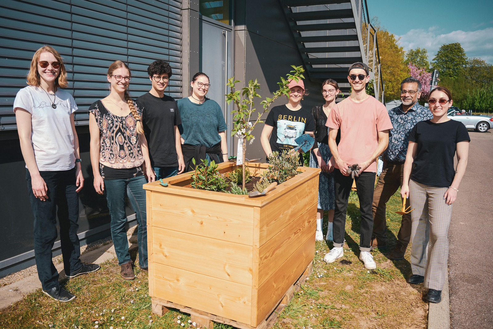 Die Mitglieder der AG Nachhaltigkeit stehen um ein Hochbeet herum 