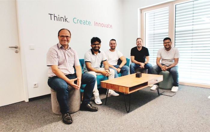 Die Projektbeteiligten sitzen unter der Überschrift Think. Create. Innovate an einem Couchtisch.