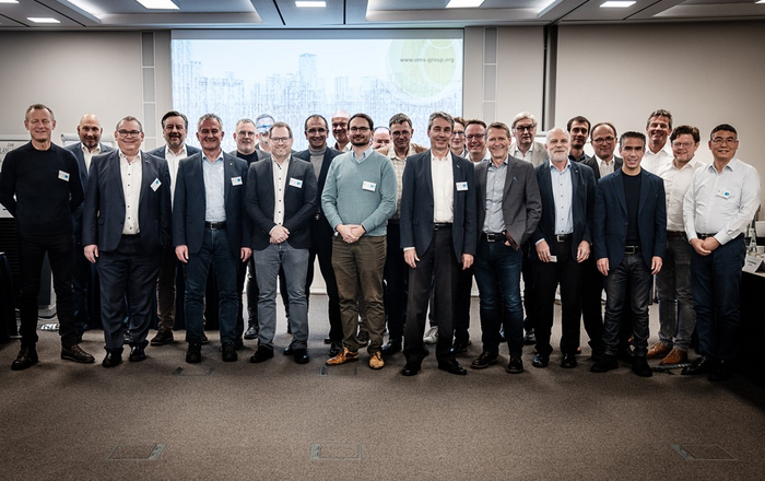 Gruppenbild der Mitglieder - 25 Personen vor einer Beamerwand