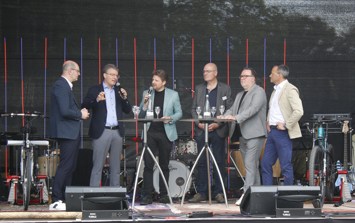 Die Redner stehen an Stehtischen auf der Bühne