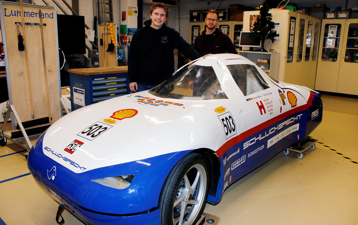 Zwei junge Männer stehen neben eine Auto