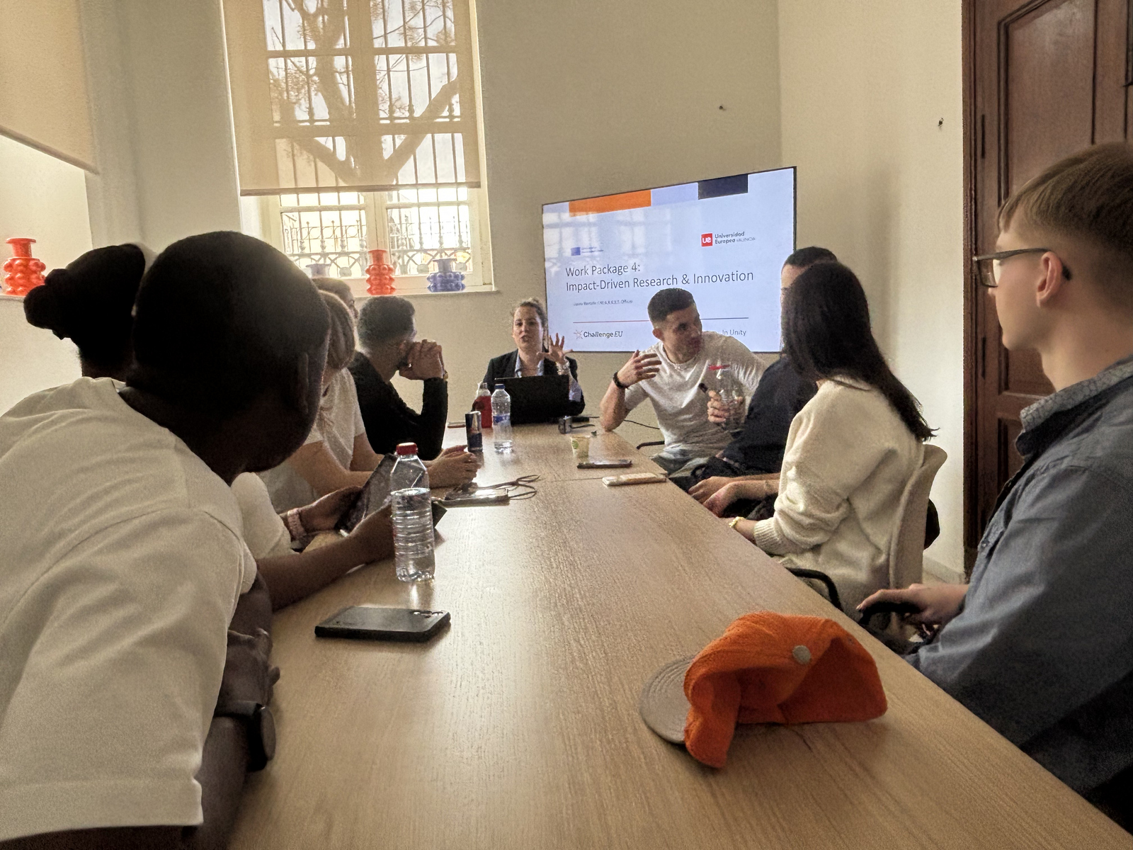 Junge Menschen sitzen um einen Tisch herum und unterhalten sich