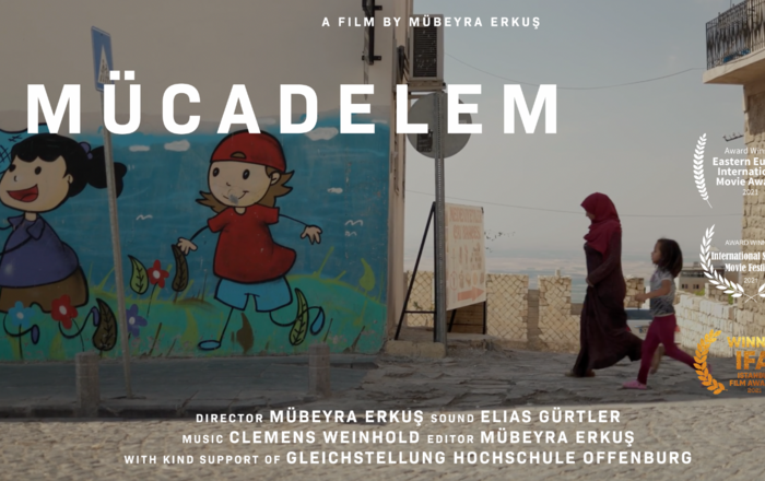 Eine Frau mit Kopftuch und ein Kind laufen an einer WAnd vorbei auf der ein Graffiti zu sehen ist auf dem ein Mädchen und ein Junge auf einer Wiese Schmetterlinge fangen