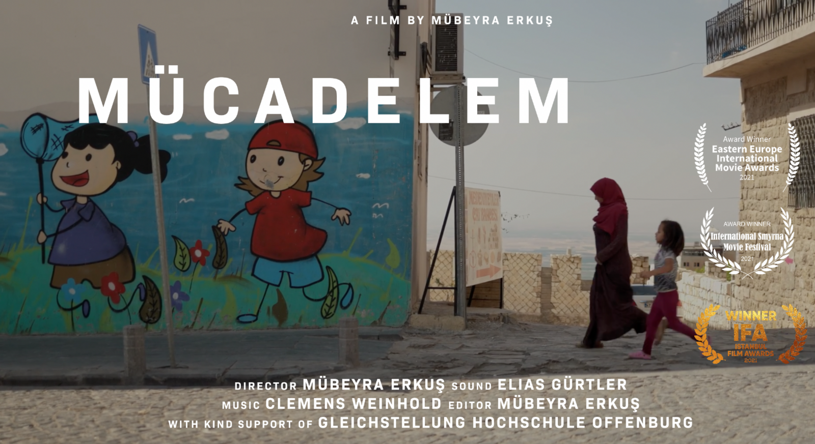 Eine Frau mit Kopftuch und ein Kind laufen an einer WAnd vorbei auf der ein Graffiti zu sehen ist auf dem ein Mädchen und ein Junge auf einer Wiese Schmetterlinge fangen