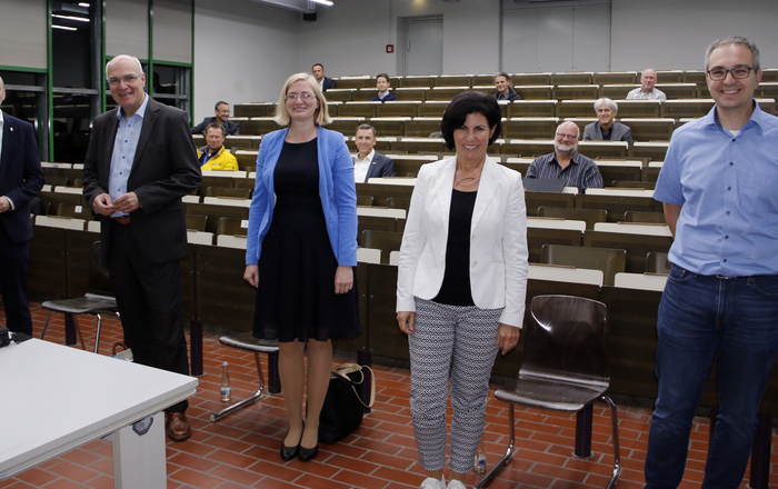 Rektor Prof. Dr. Stephan Trahasch, Helmut Schareck, Julia Migenda, Rita Böcherer und Thomas Hüger (von links) stehen in einem Hörsaal vor den sitzenden Mitgliedern..