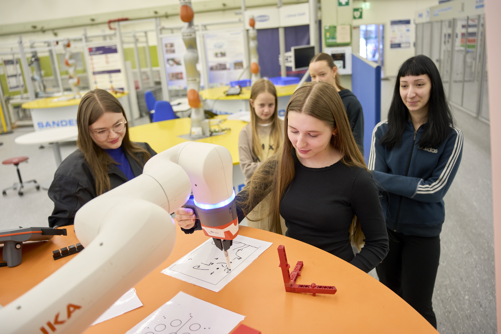 Mädchen arbeiten mit einem Roboterarm