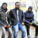 Seth Kotey, Nana Kwadwo Akrasi-Mensah und Robert Antwi von links auf einer Mauer auf dem Campus sitzend.