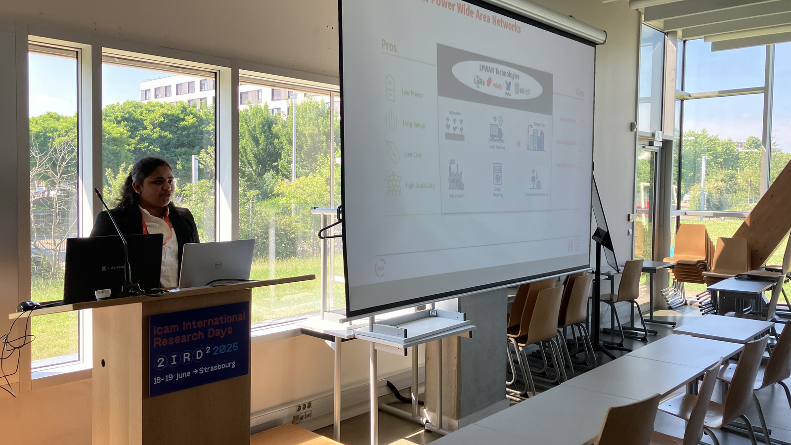 eine Person am Rednerpult neben einer Leinwand