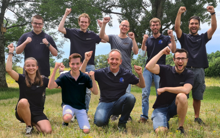 Das jubelnde Siegerteam auf einer Wiese