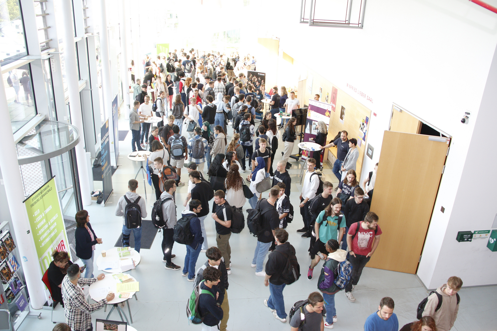 Die Stände im Foyer von Gebäude D von Menschen umringt.