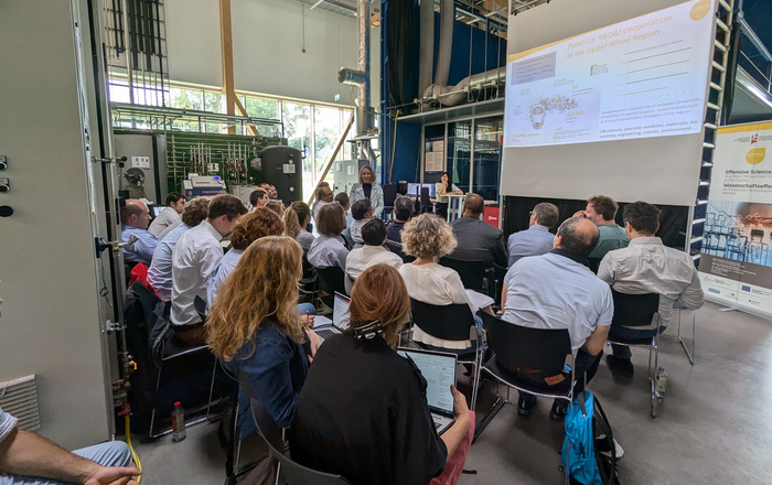 Teilnehmende sitzen im Technikum vor einer Leinwand