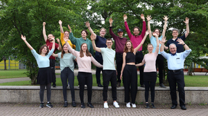 Mitglieder des Hochschulchors strecken ihre Arme in die Luft