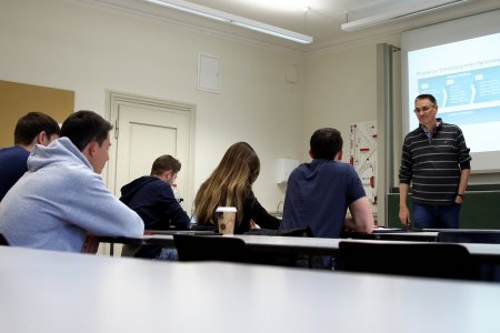 Ein Referent vor einer Gruppe sitzender Zuhörer.