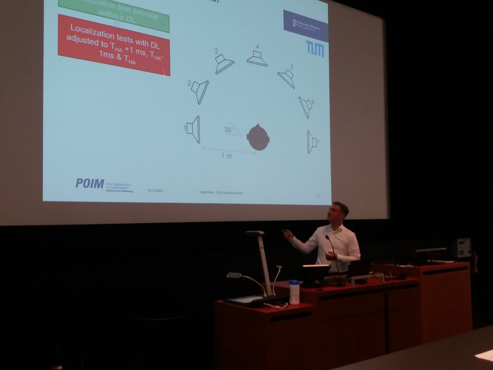 Julian Angermeier vor der leinwand mit seiner Power-Point-Präsentation. 