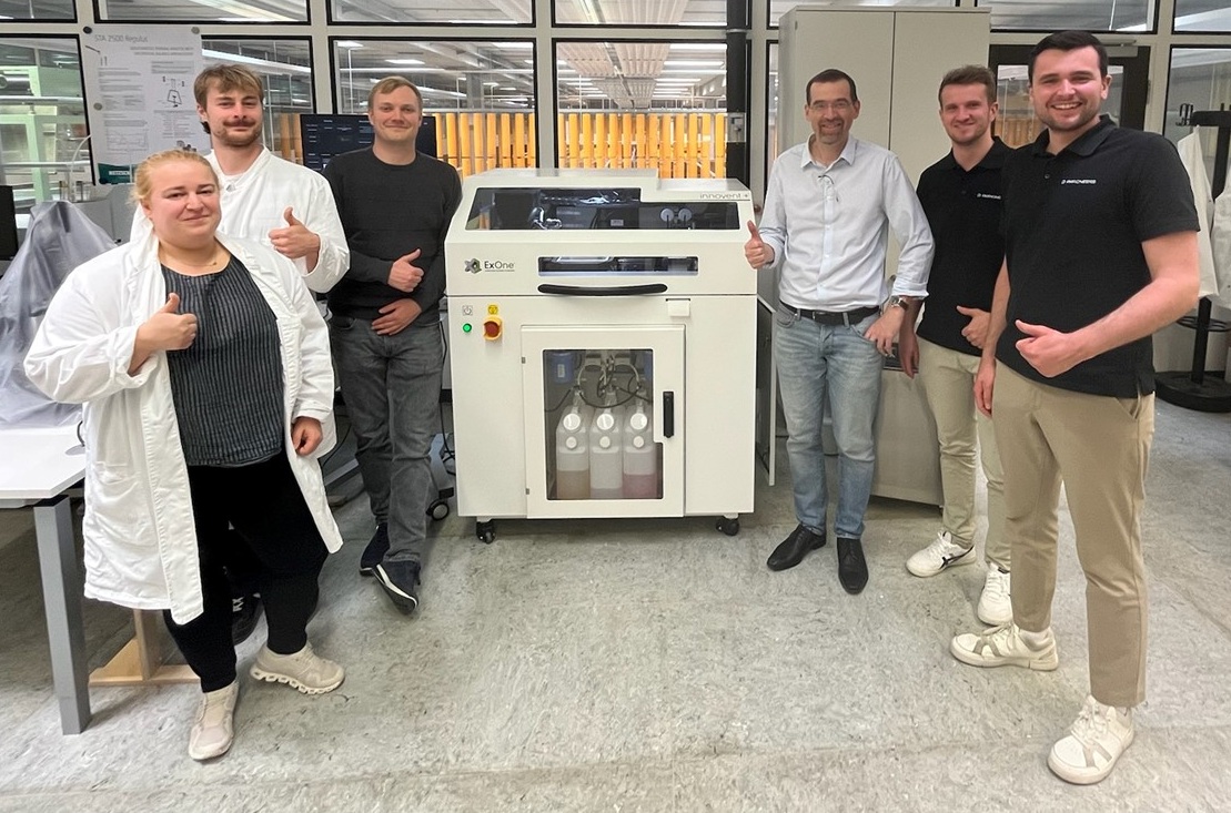 Menschen stehen in einem Labor umd das Gerät herum 