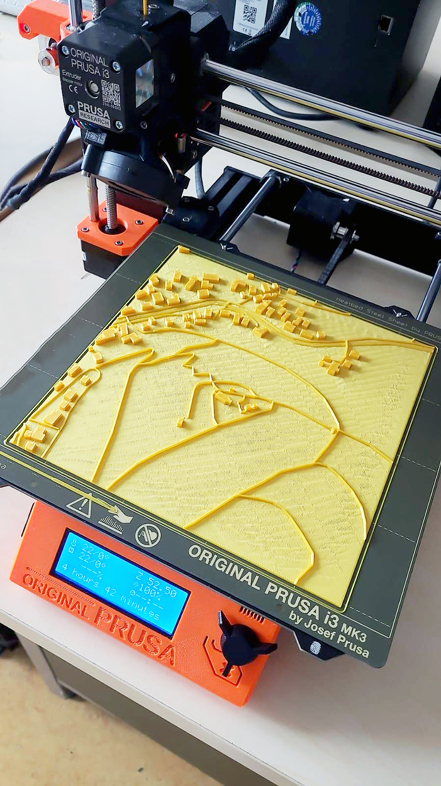 3D-Drucker auf dem ein haptisches Modell mit einer Dorf-/Stadtansicht steht