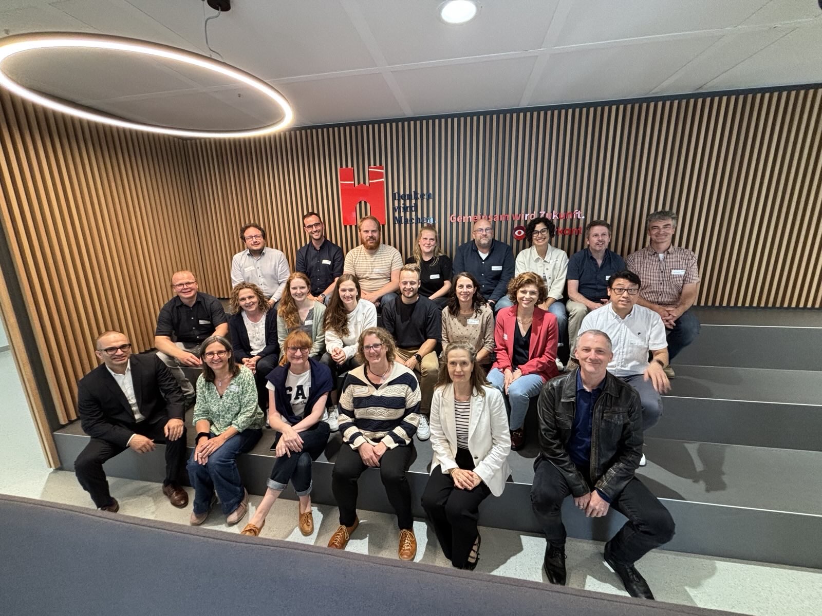 Die Teilnehmenden der Konferenz, sitzend im foyer des Gebäude A