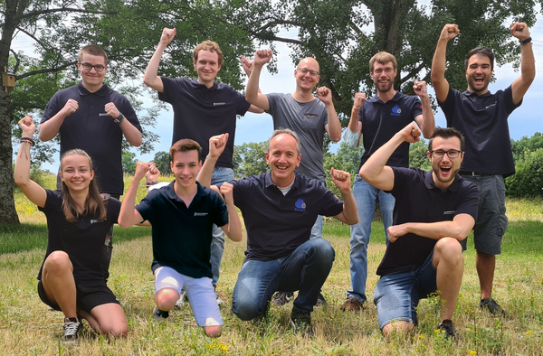 Das jubelnde Siegerteam auf einer Wiese