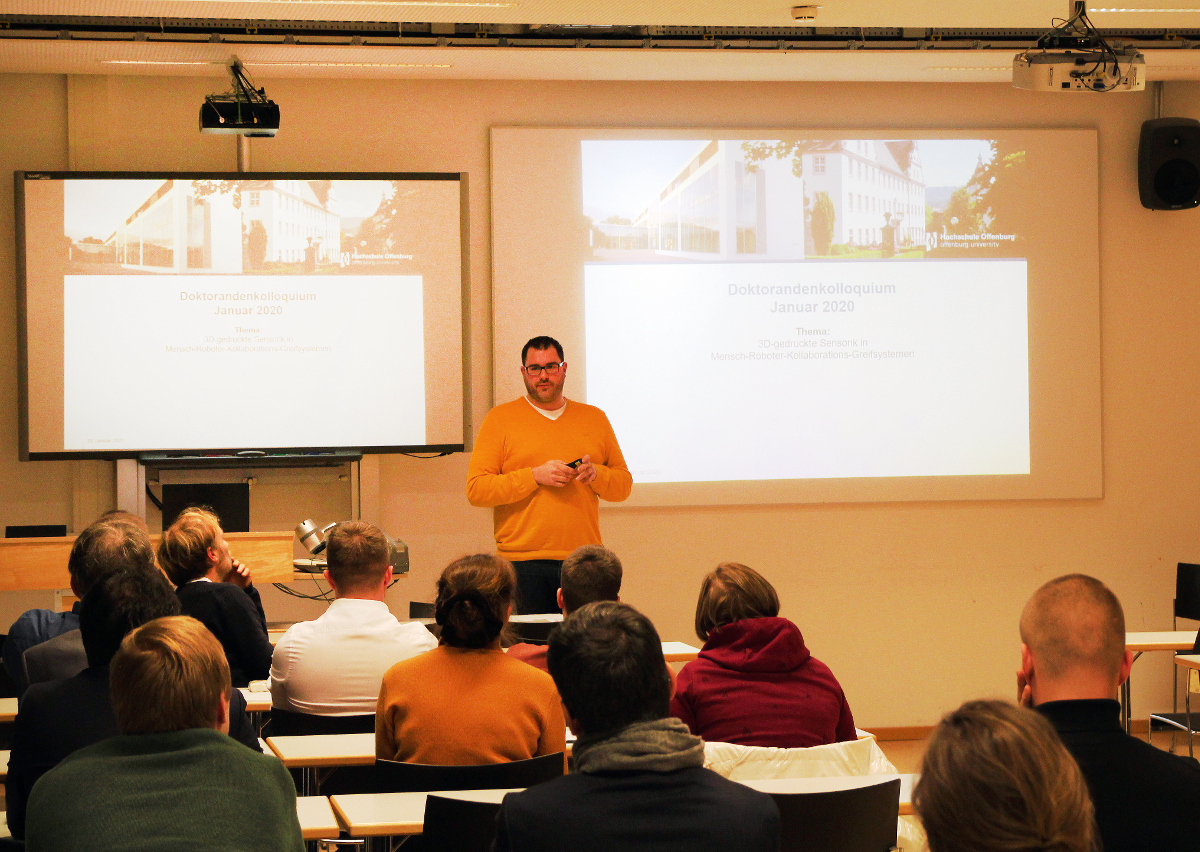 Doktorand stellt seine Arbeit in Seminarraum vor